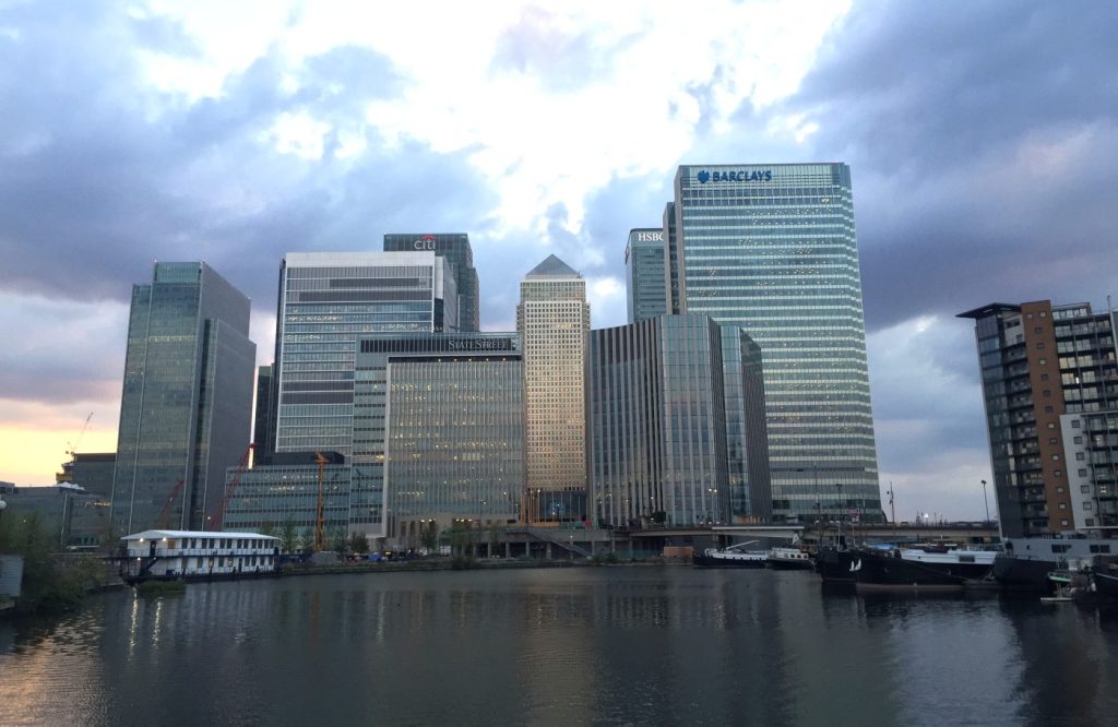 Vista de los rascacielos de Canary Wharf desde el muelle, con el reflejo en el agua al atardecer