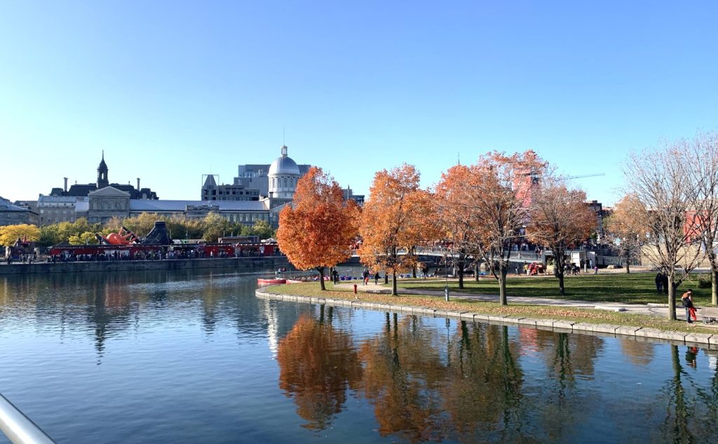Canal en Montreal con árboles otoñales y reflejos, junto al Bassin Bonsecours y el Mercado de Bonsecours al fondo