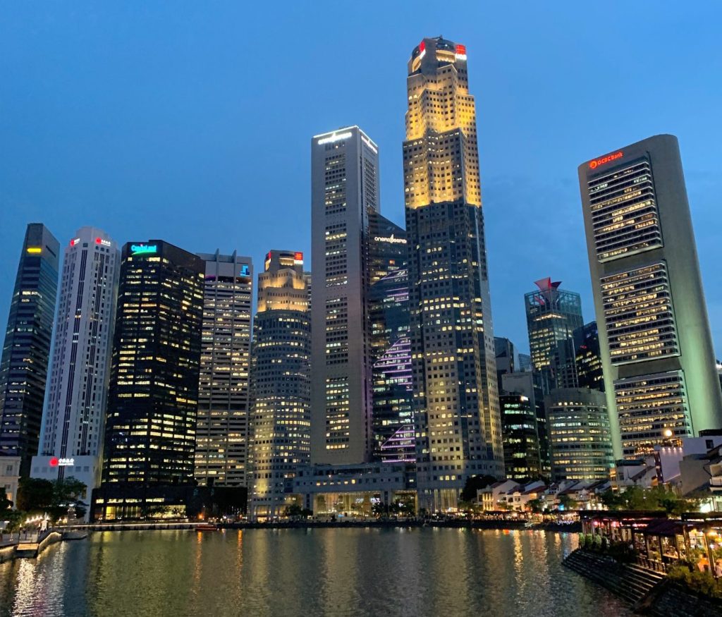 Skyline del distrito financiero de Singapur iluminado al anochecer, visto desde Marina Bay